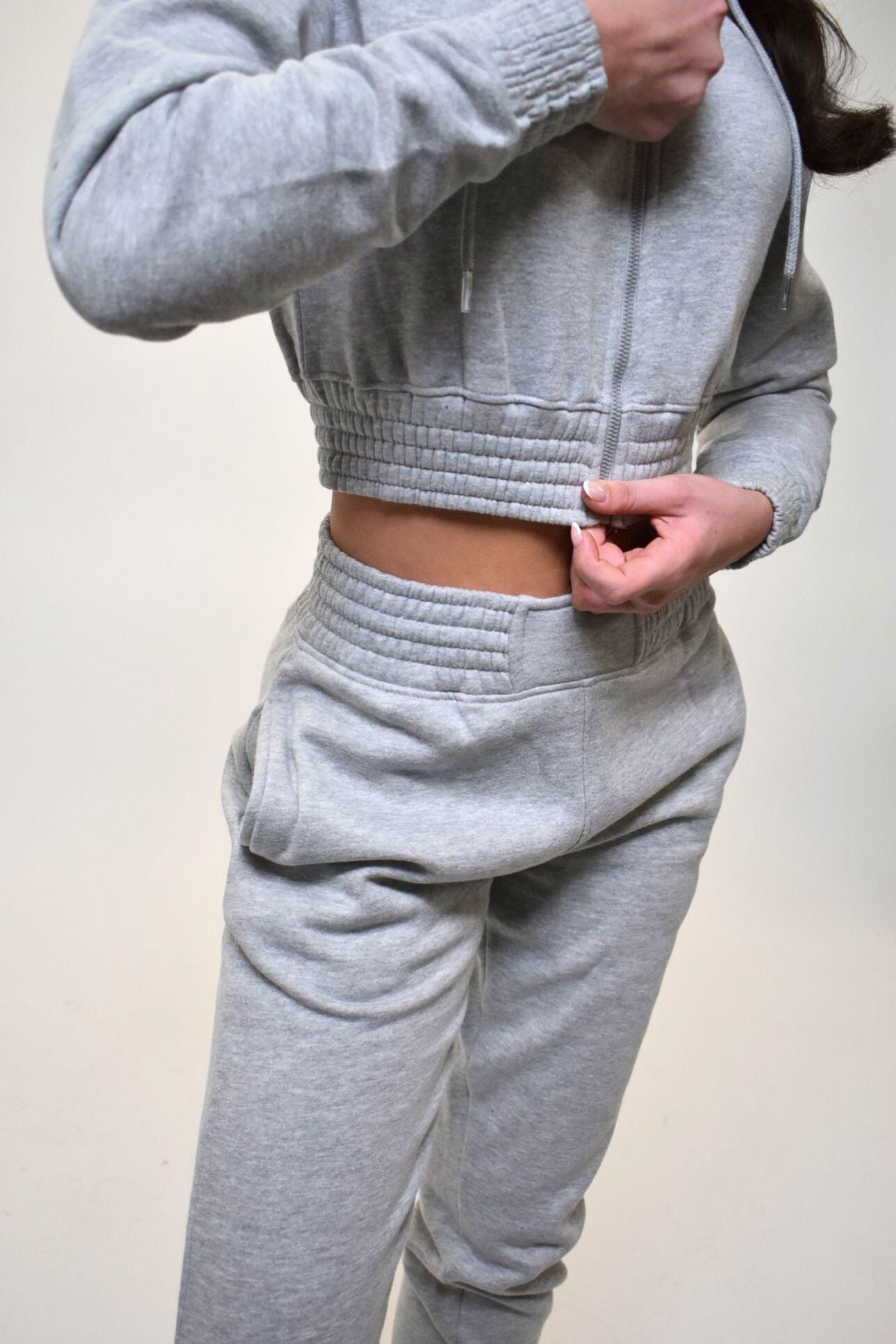 Gray tracksuit worn by a person on a plain background